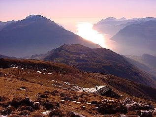 Il rifugio Prospero Marchetti, sullo sfondo tramonto sul lago di Garda Il rifugio Prospero Marchetti, sullo sfondo tramonto sul lago di Garda