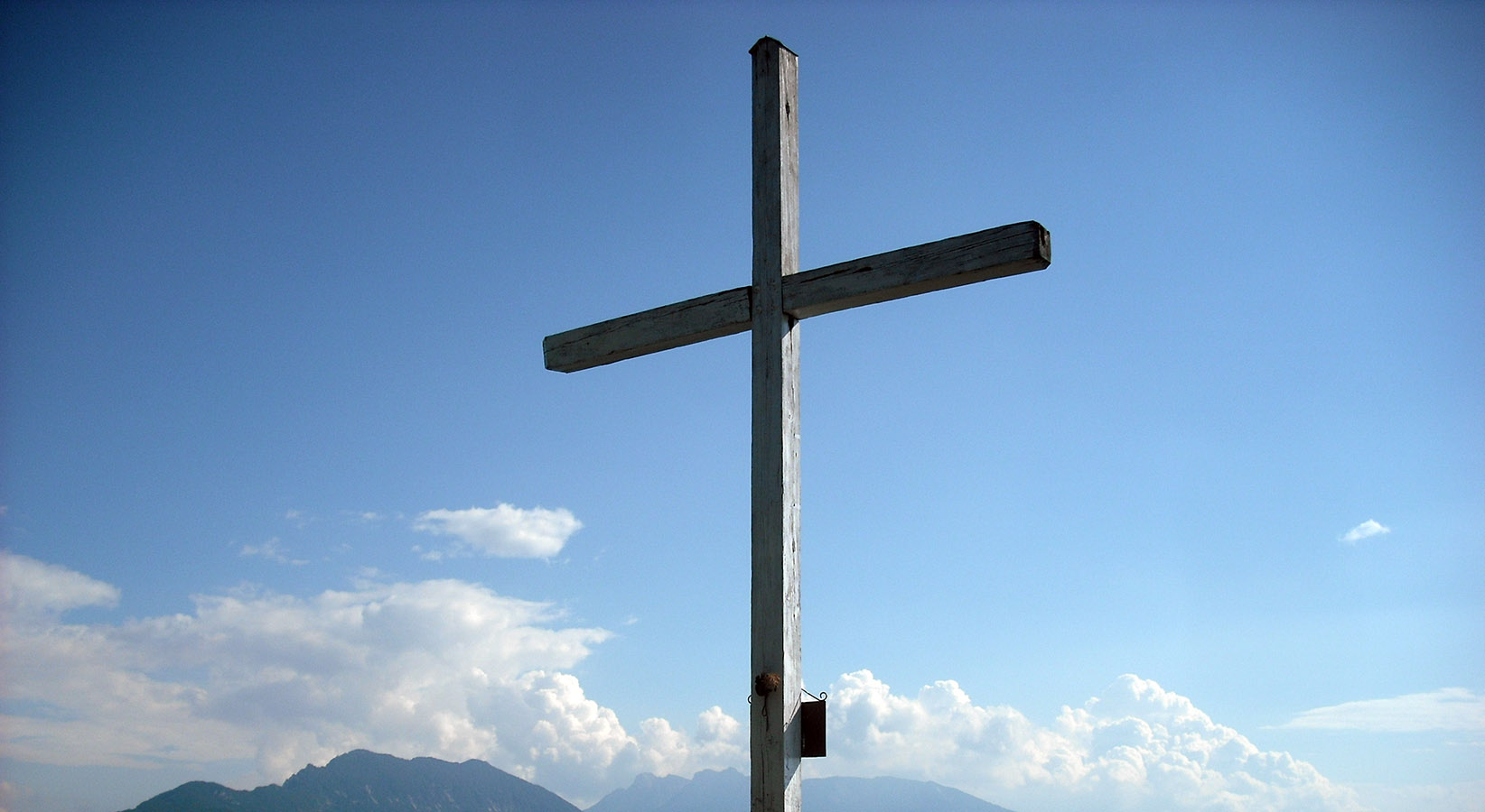 Croce di vetta sul Monte Calisio sullo sfondo il “Marzola” e il gruppo della “Vigolana”